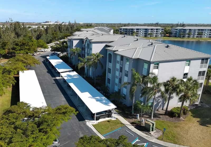 Representative aerial view of a Southwest Florida condo community with tile roofing and white carport covers