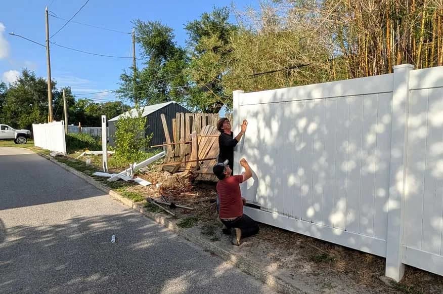 Seacoast crew installing a new white vinyl privacy fence to replace a storm-damaged wood fence in Southwest Florida