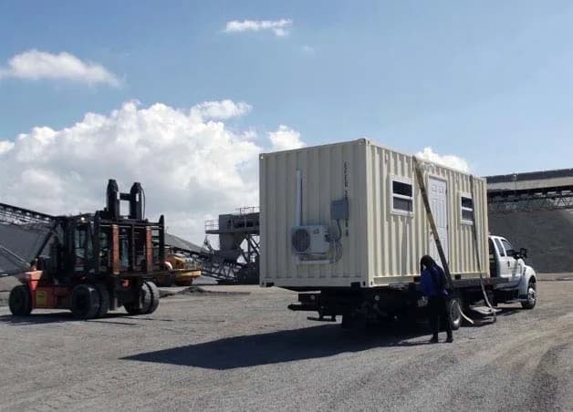 Representative image of a container being placed from a flatbed truck