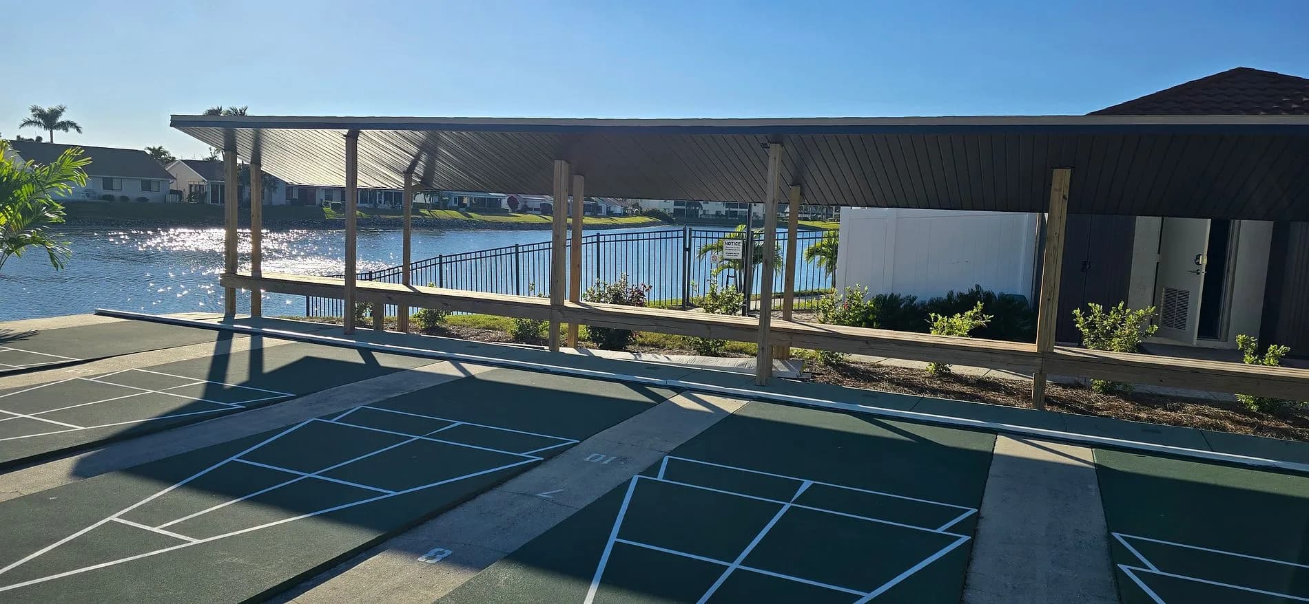 Cinnamon Cove shuffleboard courts and covered seating beside the lake