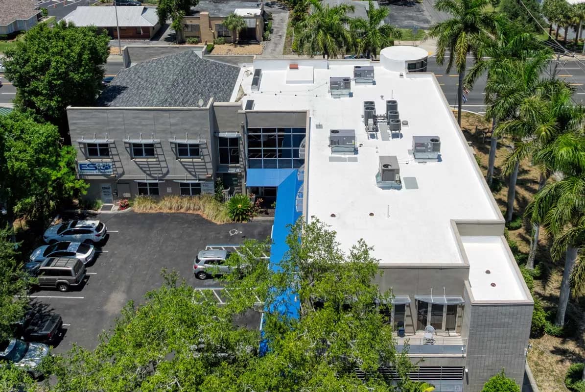Representative aerial inspection view of a commercial building with a white reflective flat roof in Southwest Florida